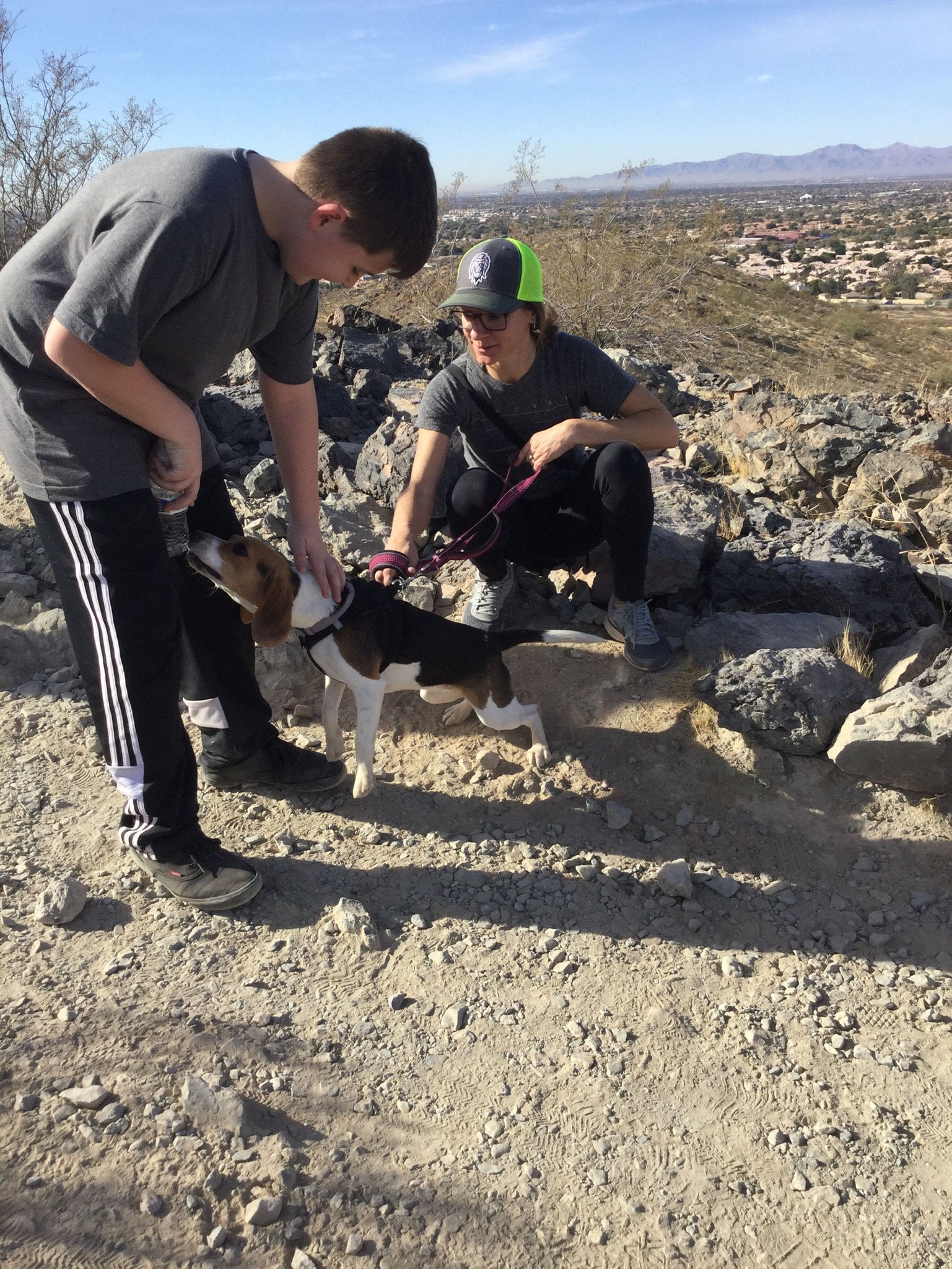 two people and a beagle bonding outdoors during a hike